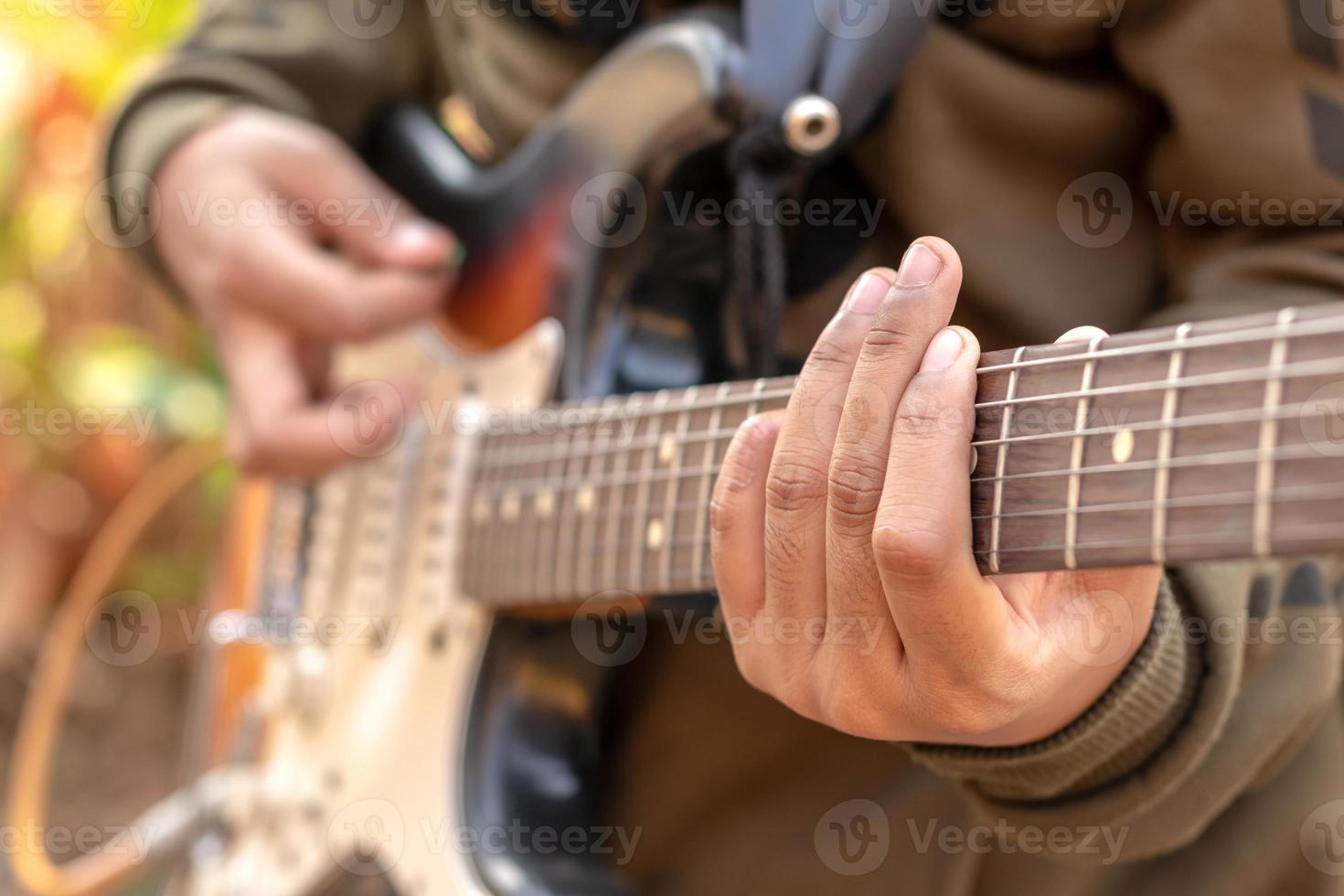 mano femenina tocando la guitarra eléctrica al aire libre. foto