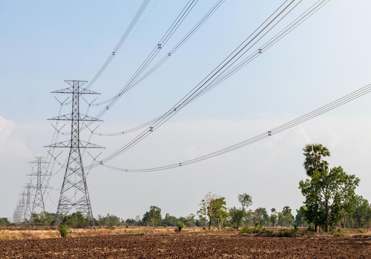 poste de alto voltaje en el campo de tierra. foto