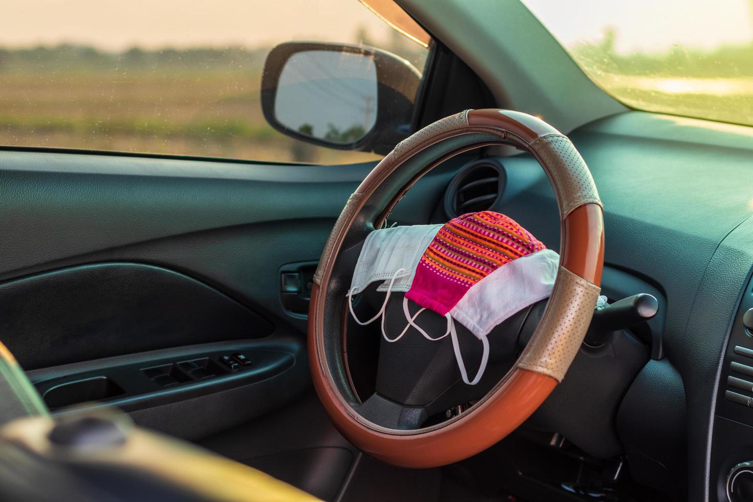 muchas máscaras faciales se colocan en el volante dentro del automóvil. foto