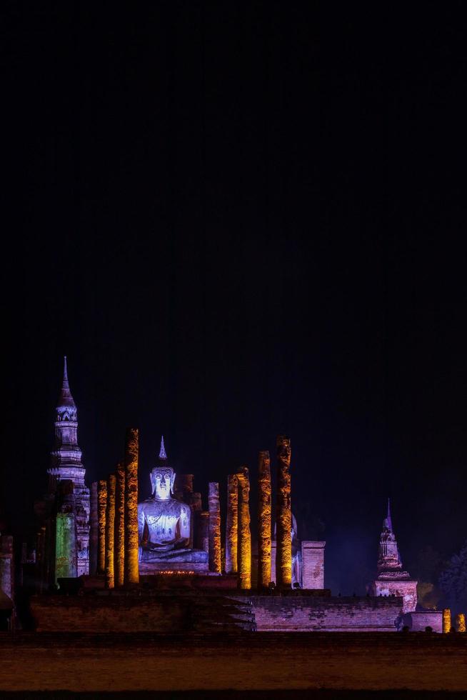 Old Buddhist temple at night with colorful lights. photo