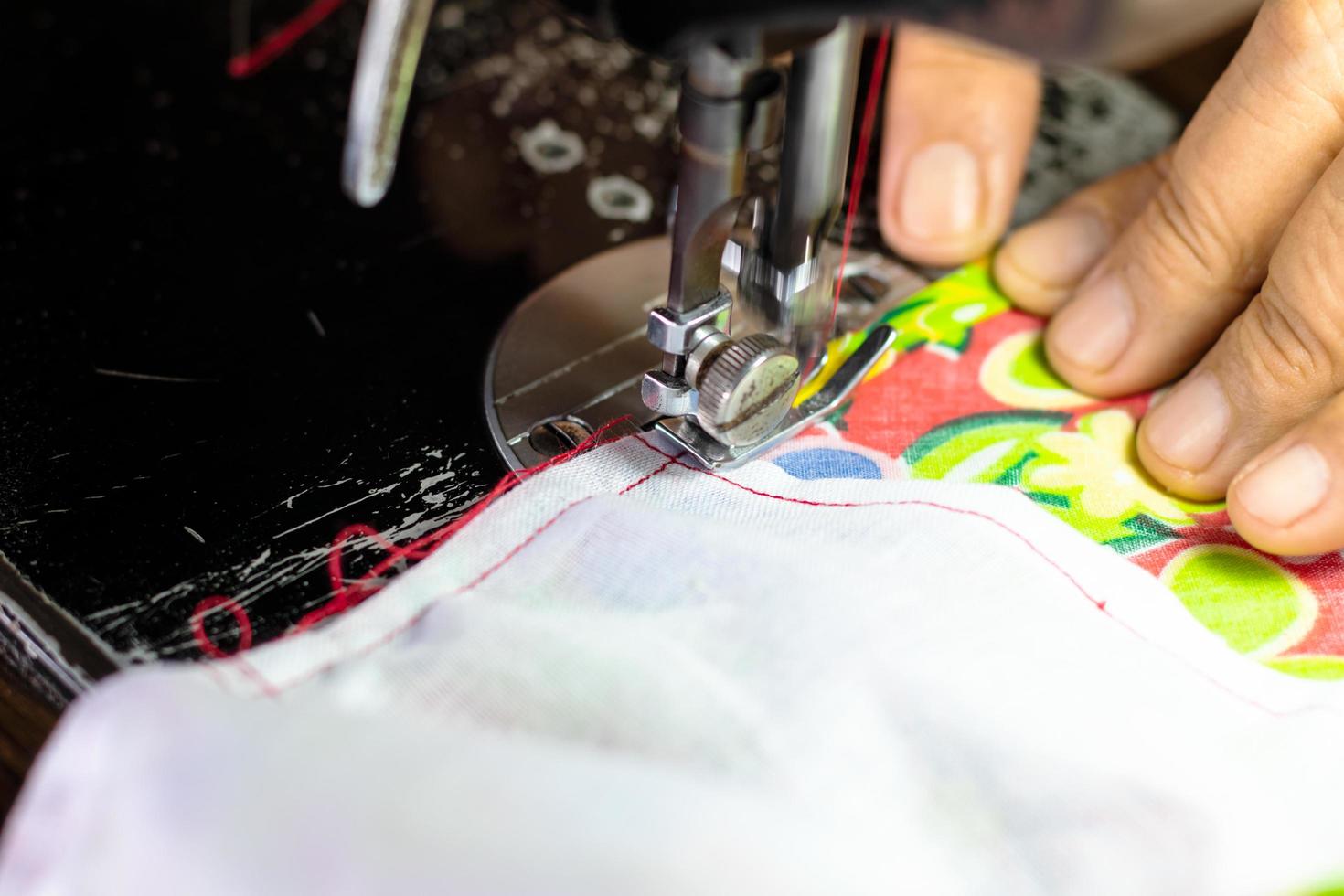 A close up, sewing the fabric on the old machine. photo