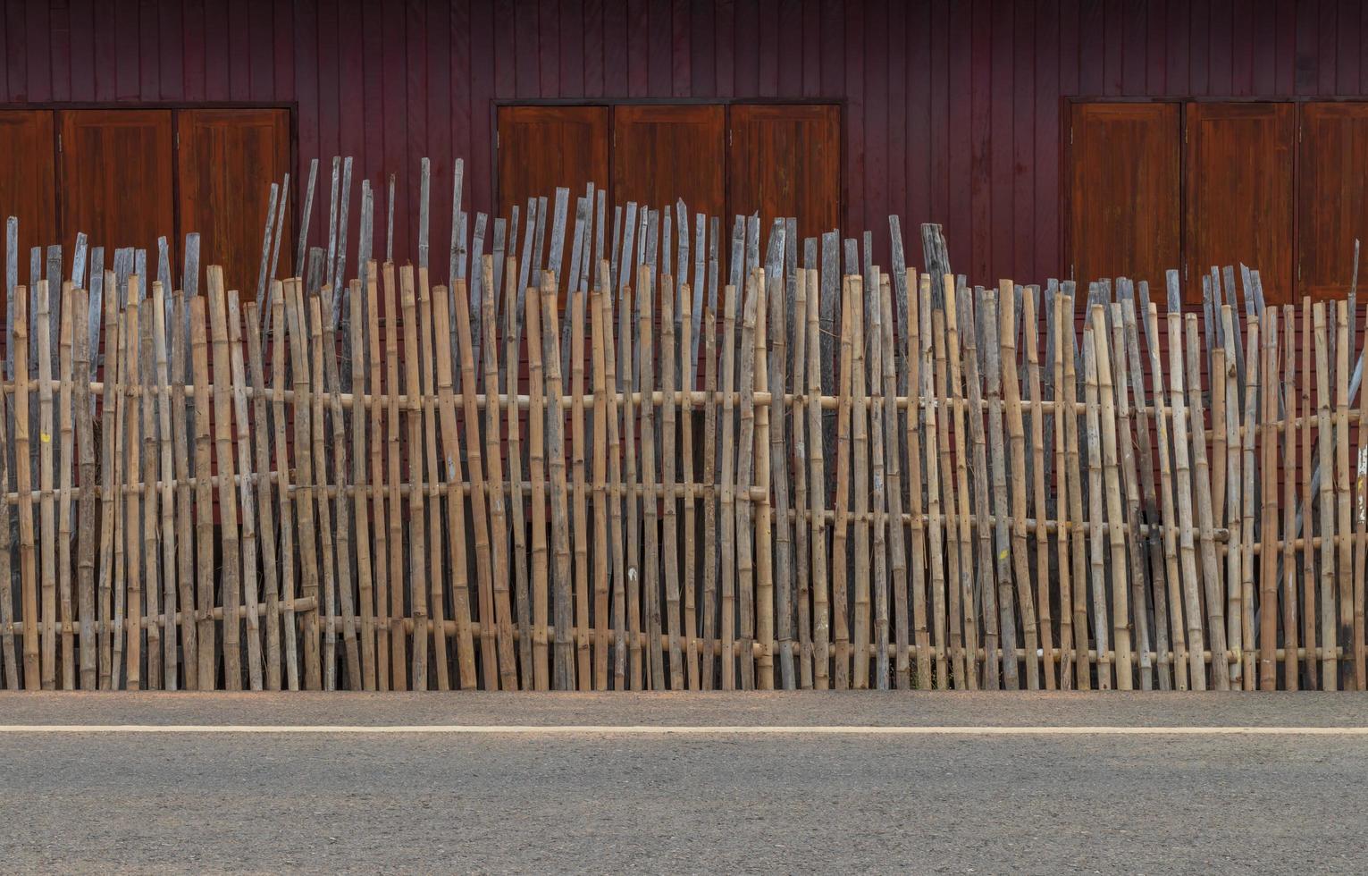 valla de bambú cerca de ventanas de madera. foto