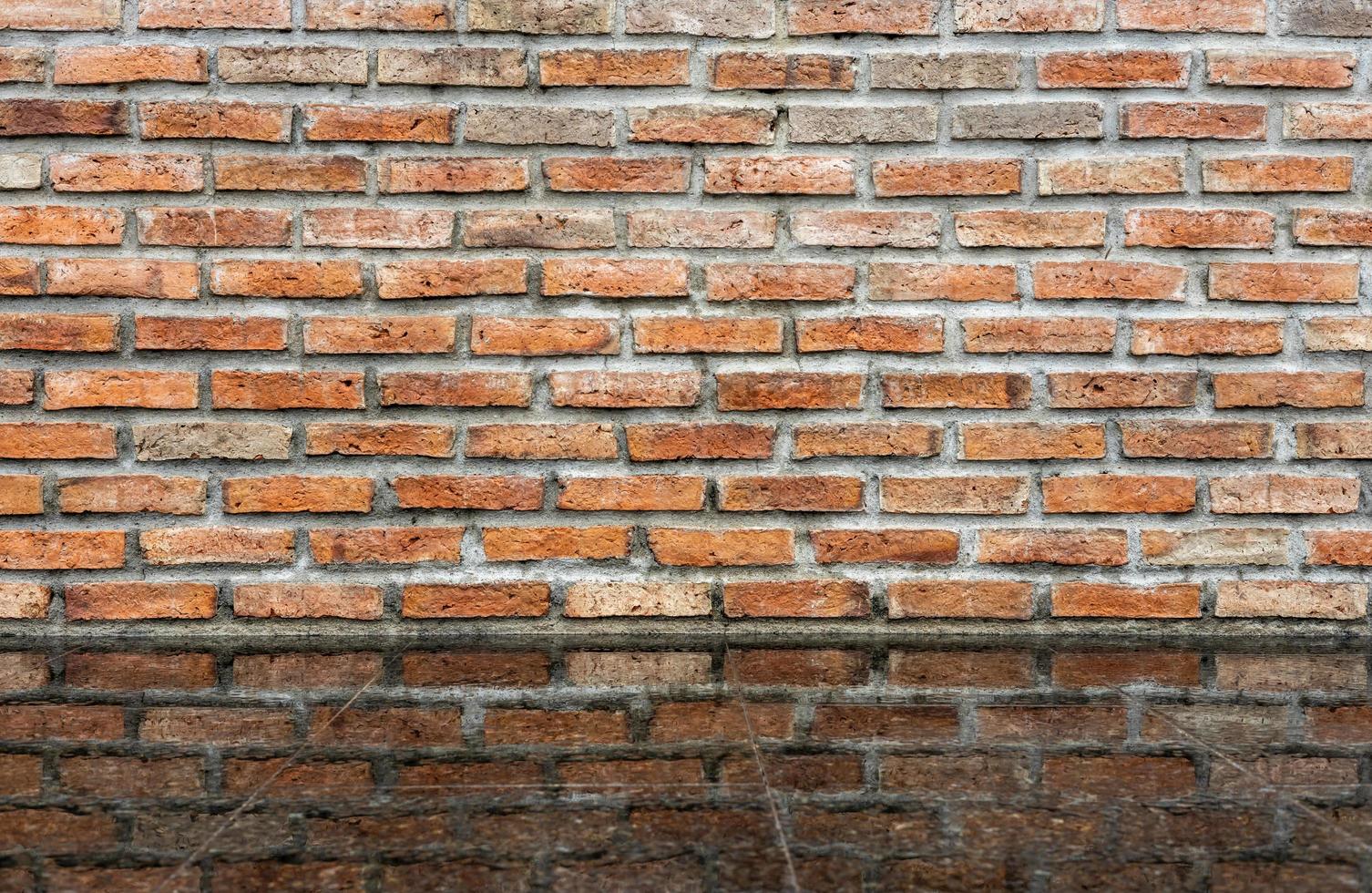 Old brick wall background with water reflection on terrazzo tile floor. photo