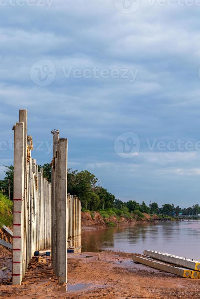 Many views of concrete columns near the river shore. photo