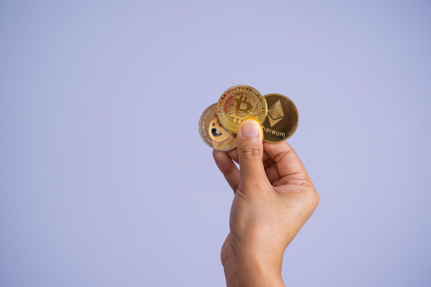 Golden bitcoin coin Dogecoin DOGE, Ethereum ETH group included with Cryptocurrency on hand woman or girl Filed and put and give to me purple background. Close up and Macro photography concept. photo