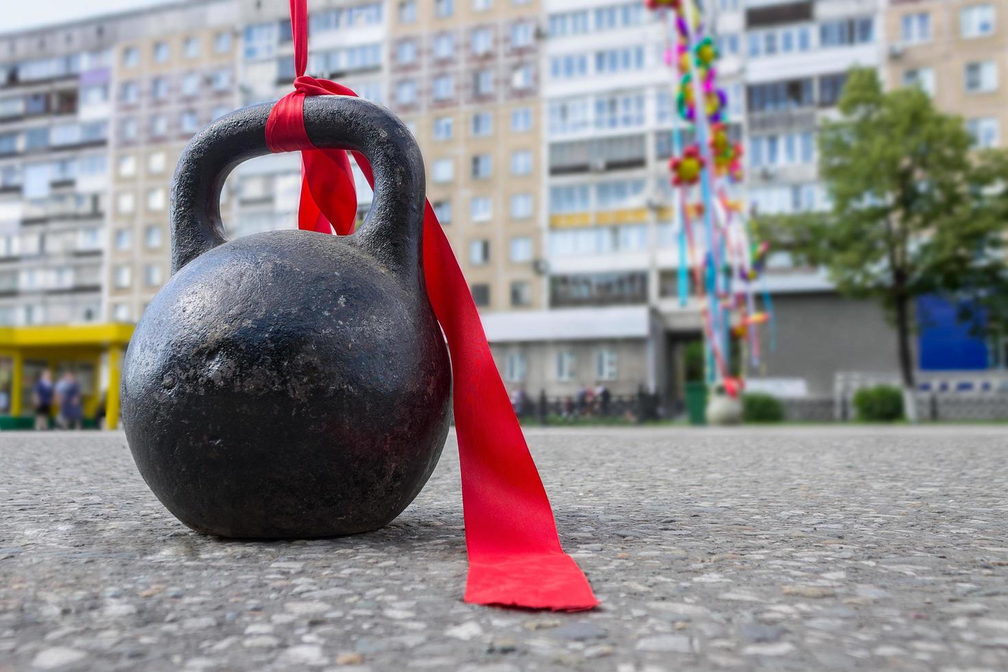 Sports equipment with a red ribbon for bodybuilding is on the asphalt during a sports holiday photo