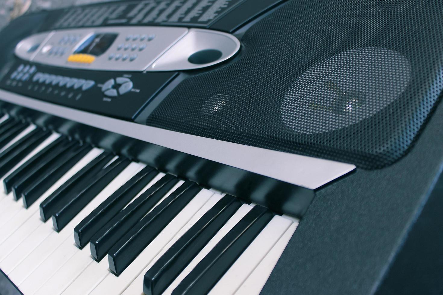 Close-up of a musical electronic synthesizer and its keys with a speaker photo