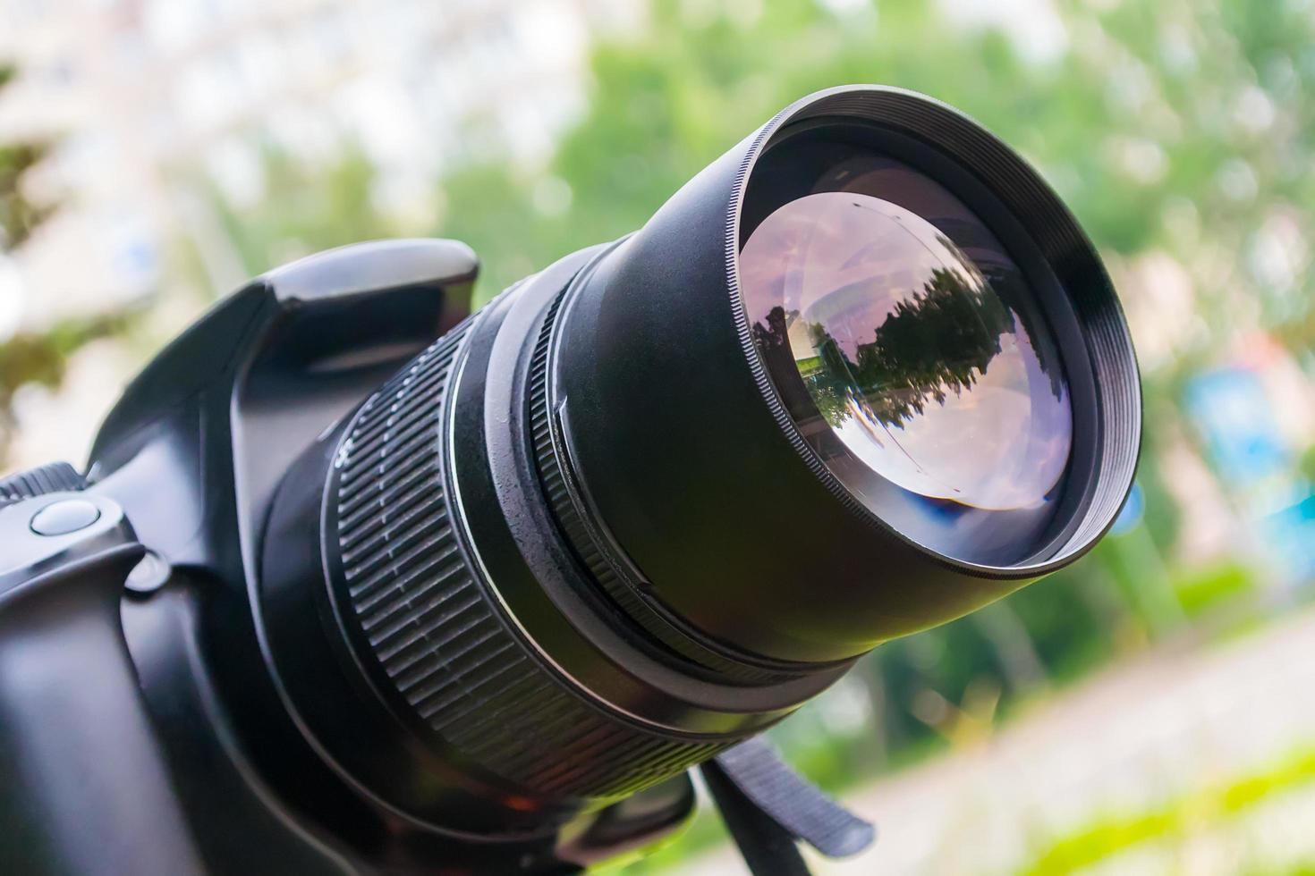 Close-up camera lens during shooting in city park in summer photo