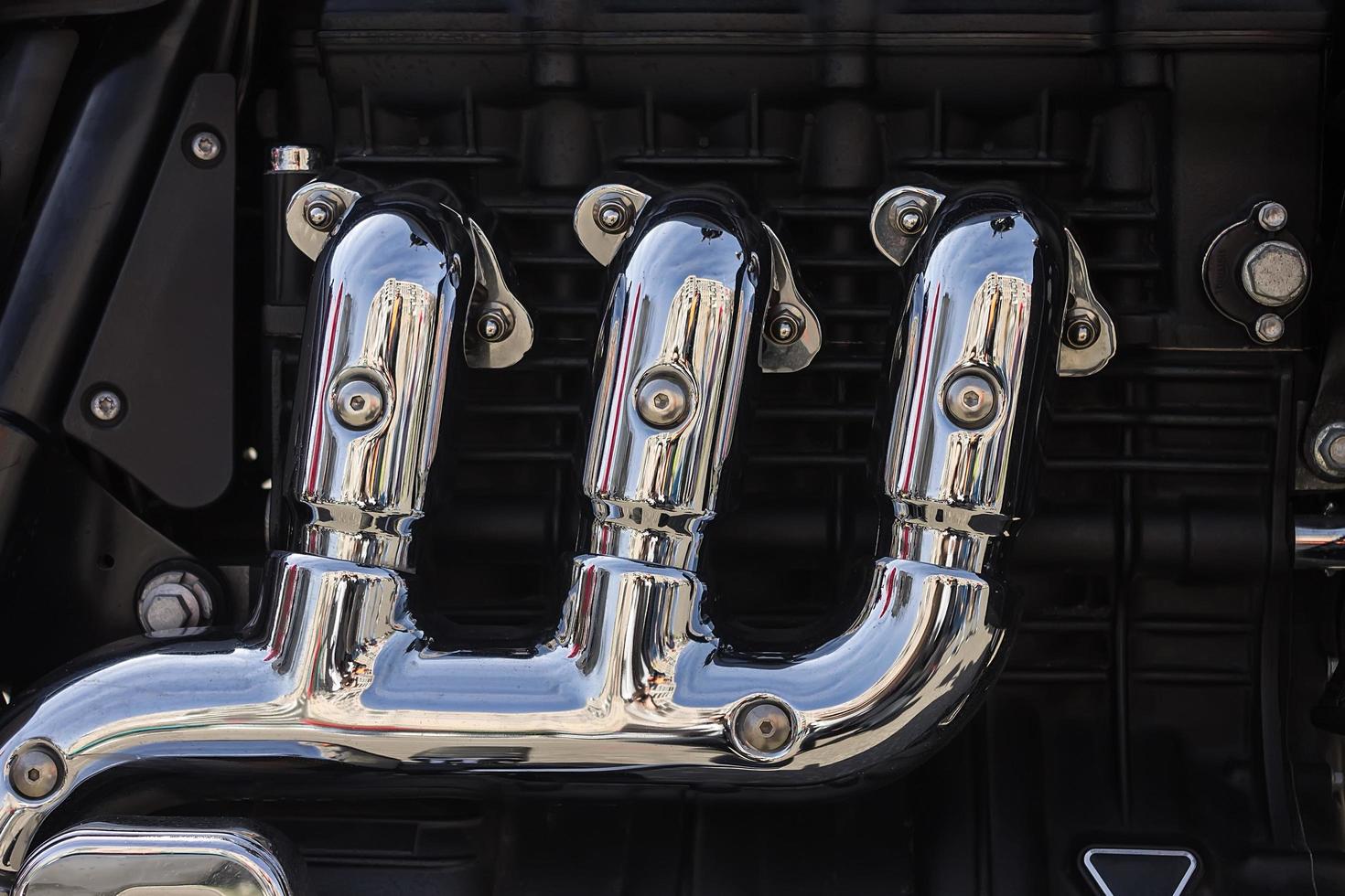Chrome motorcycle exhaust system near the engine photo