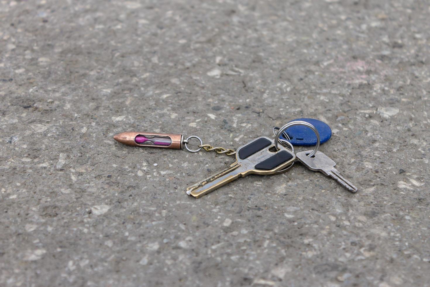 Lost bunch of old keys with a key fob on the road in a city park photo