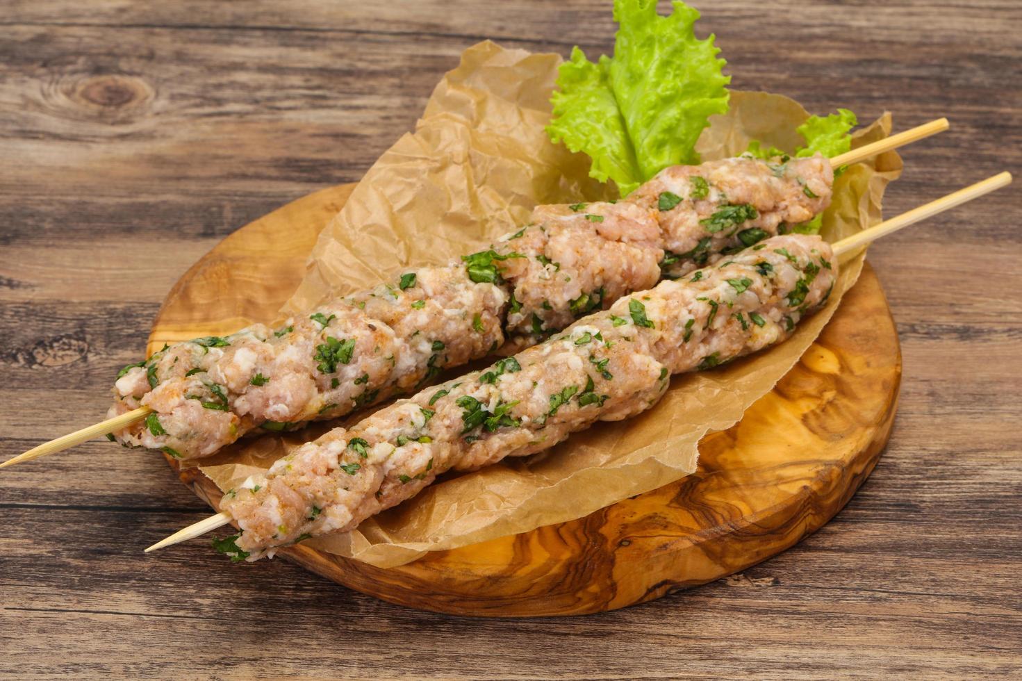 Raw minced pork skewer kebab for grill photo