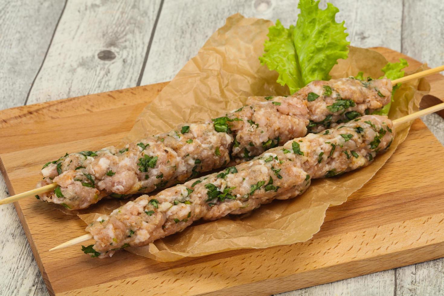 Raw minced pork skewer kebab for grill photo