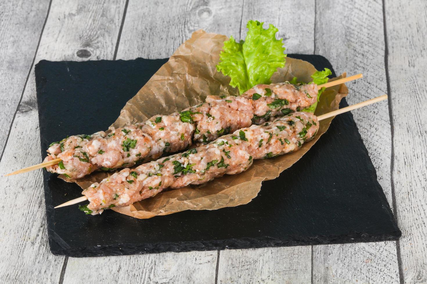 Raw minced pork skewer kebab for grill photo