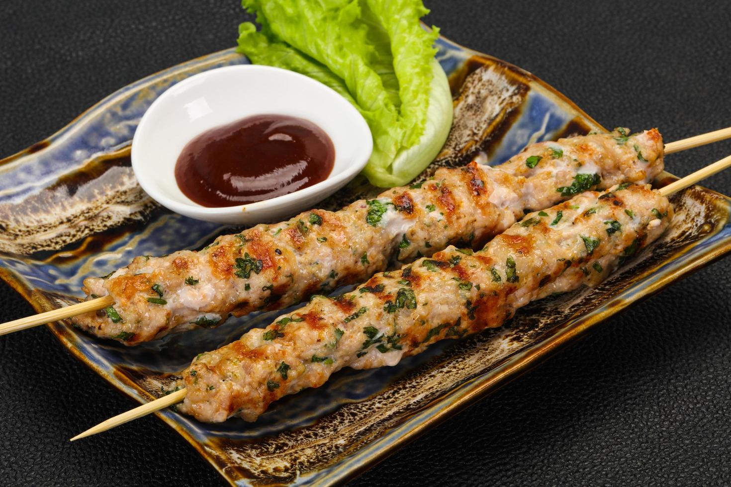 Minced pork skewer kebab with sauce photo