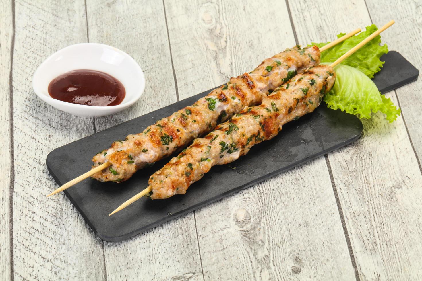 Minced pork skewer kebab with sauce photo