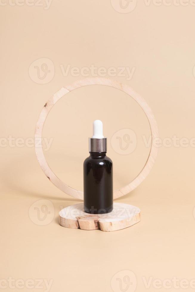 Wooden podium or pedestal with a dropper bottles of cosmetics oil or serum. Neutral beige monochrome skin care concept photo