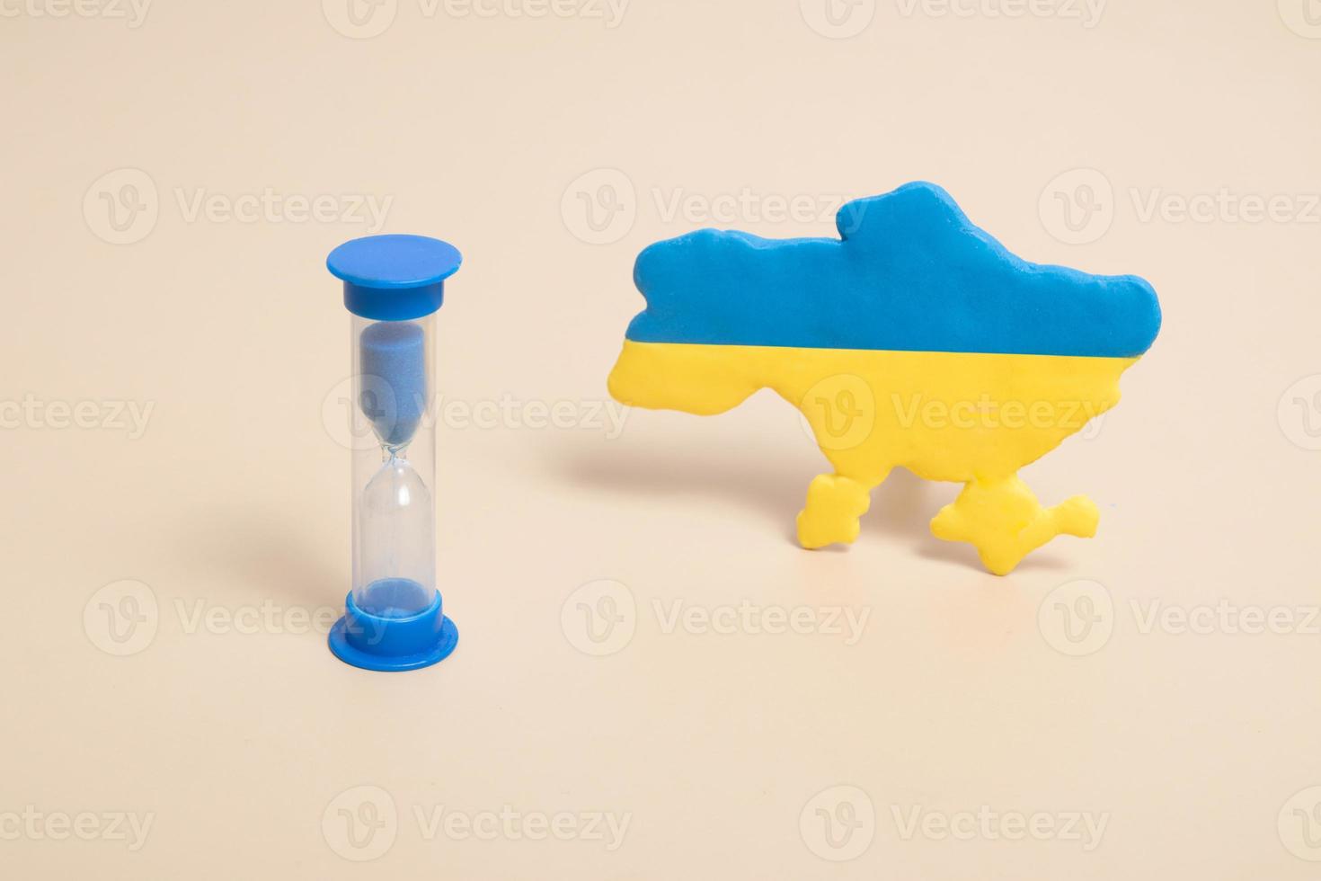 Hourglass.and plasticine yellow and blue map of Ukraine photo