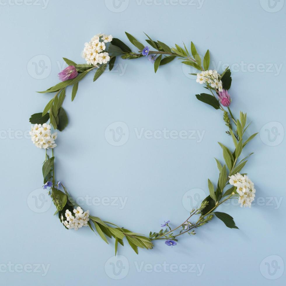 Floral round frame with copy space on a blue background. Summer or spring floral minimalistic background photo