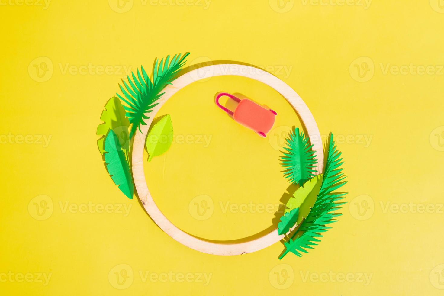 Wooden frame with tropical paper leaves and travel suitcase with copy space top view photo