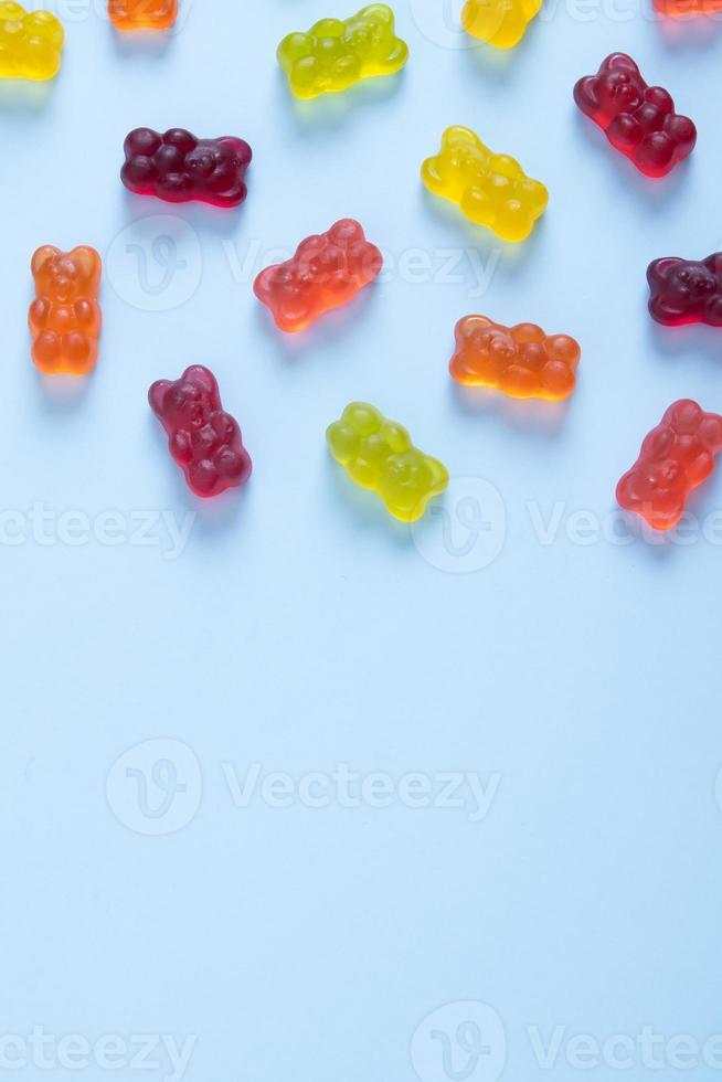 Colored jelly bears on a pastel blue background with copy space. Top view photo