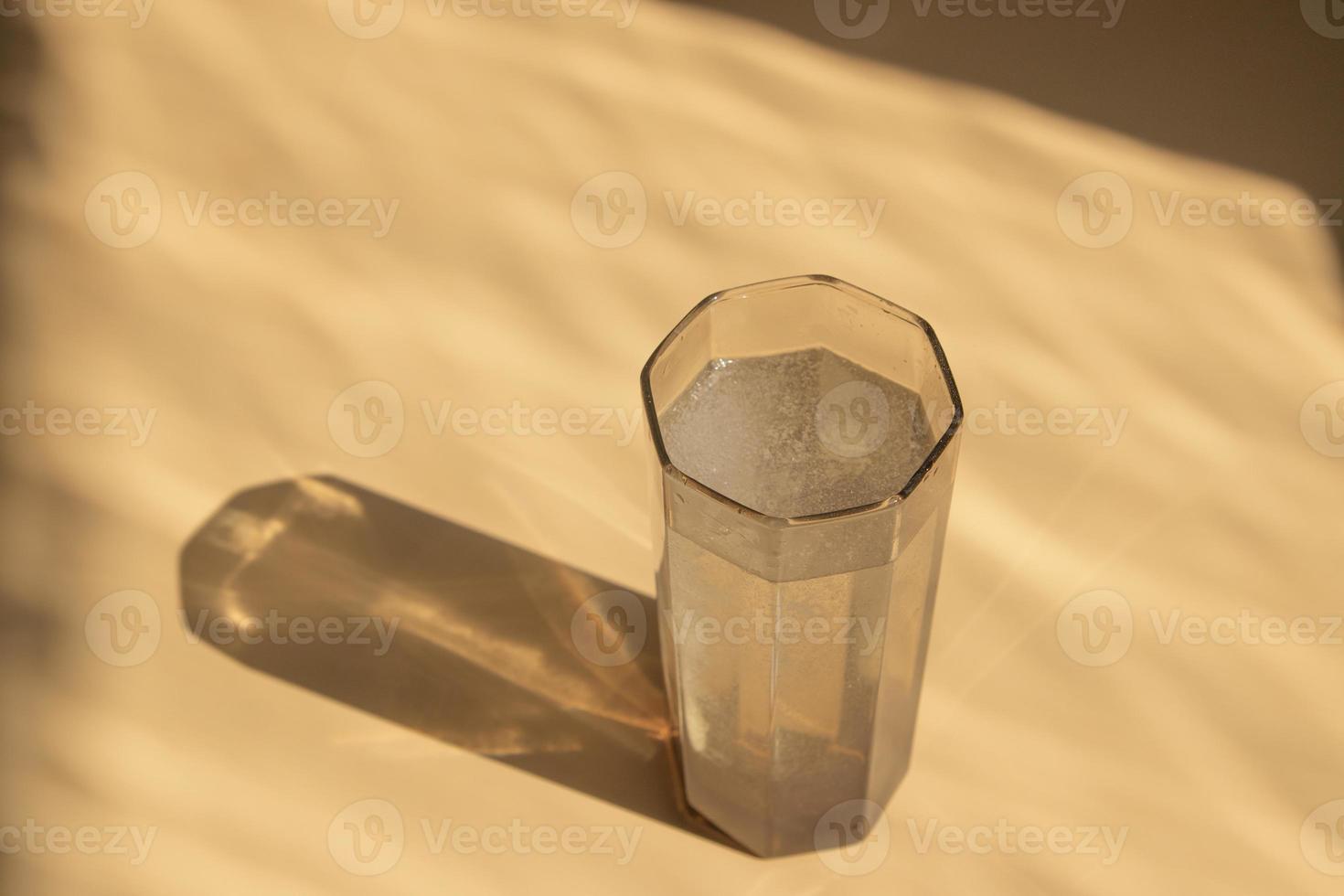 The effervescent tablet dissolves in a glass of water photo