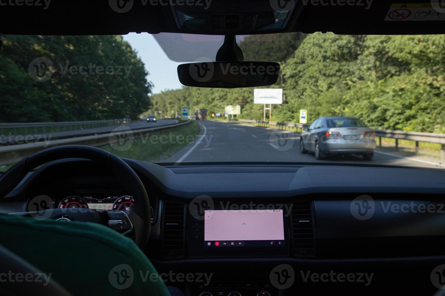 Car interior on the road. Steering wheel, dashboard and on-board display photo