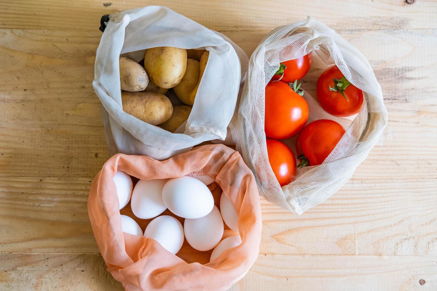 Colorful fresh fruits vegetables and eggs  in eco friendly bags photo