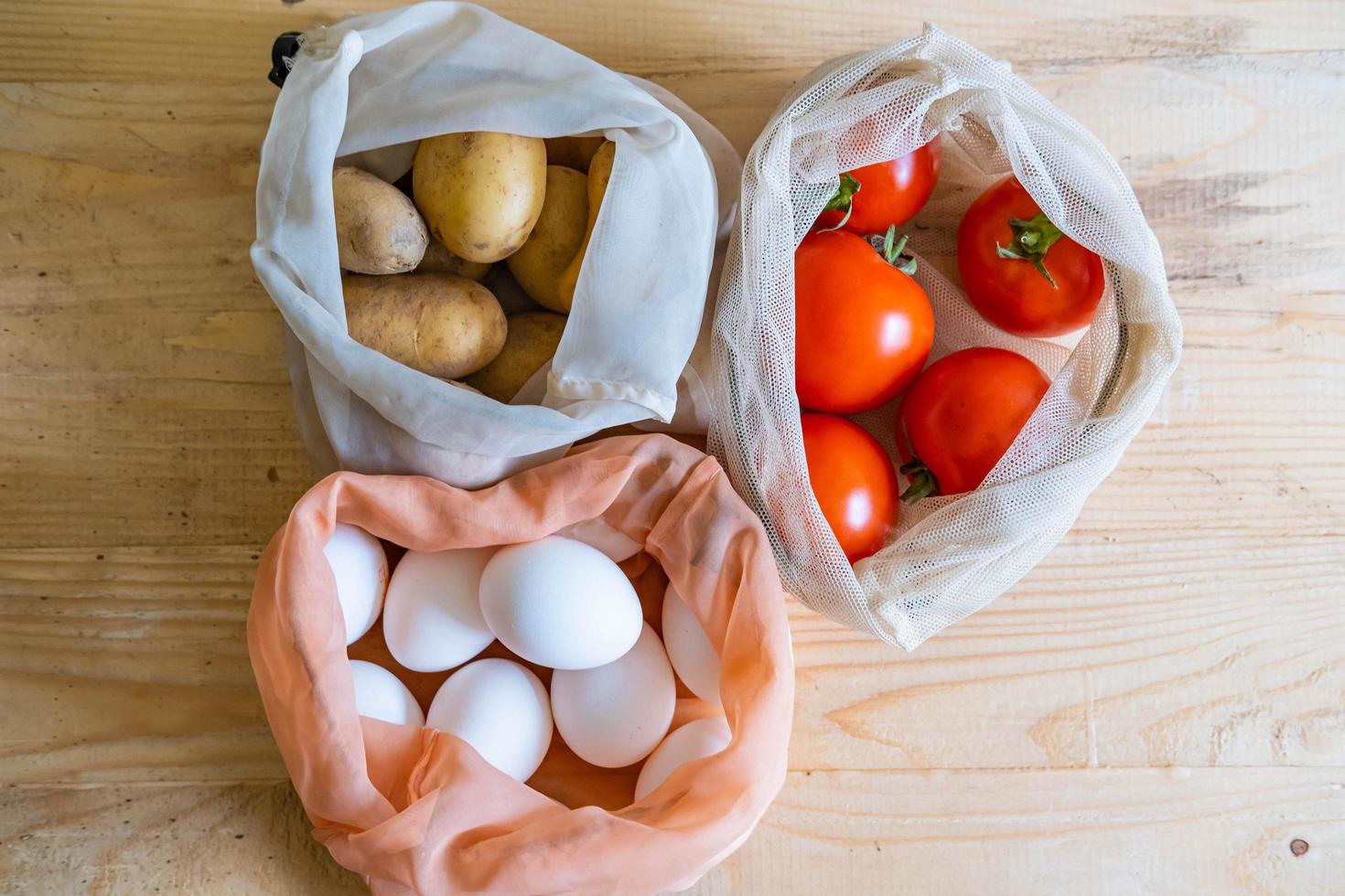 Colorful fresh fruits vegetables and eggs  in eco friendly bags photo