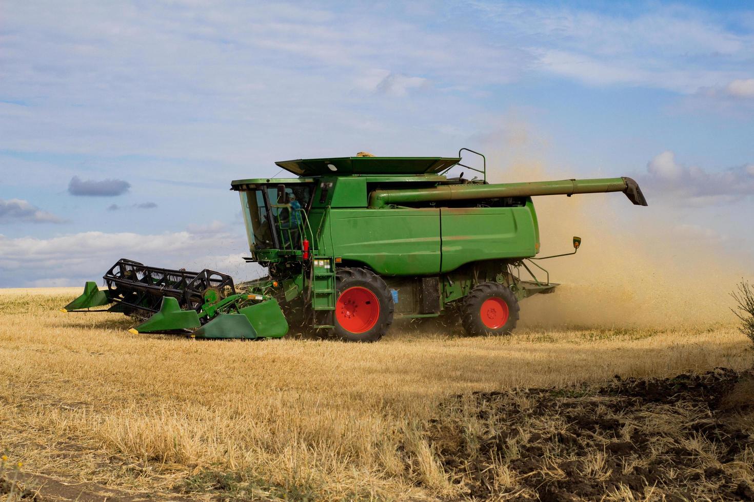big harvester works in summer wheat fierlds photo