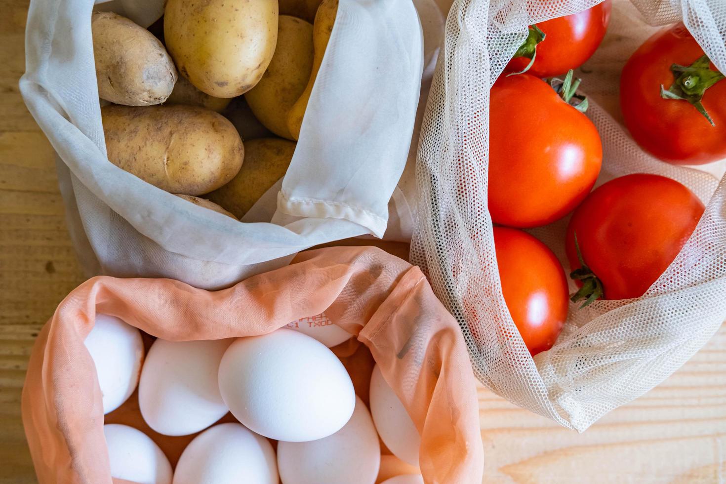 Colorful fresh fruits vegetables and eggs  in eco friendly bags photo