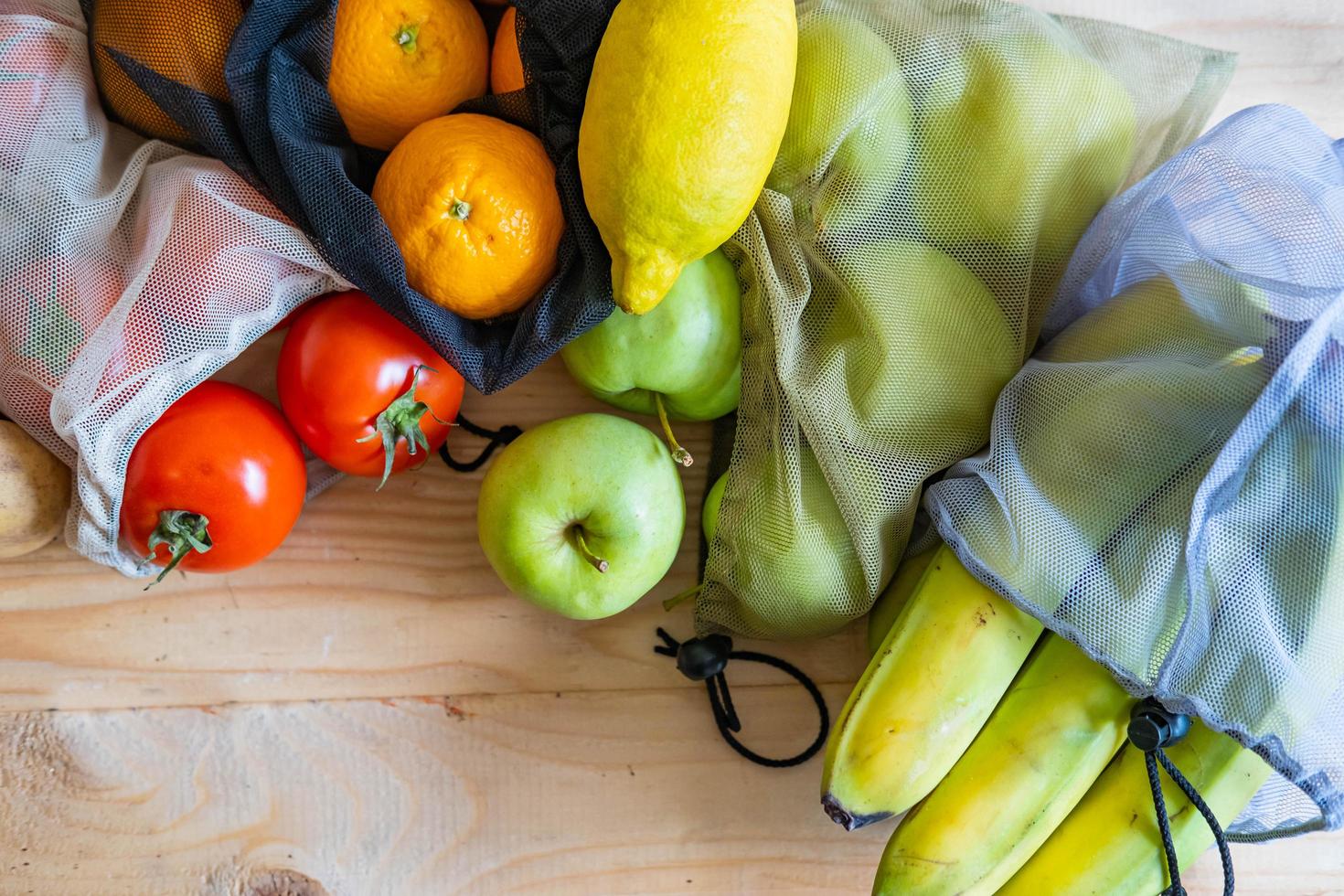 vegetables and eggs in eco friendly cotton bags on woofen table. photo