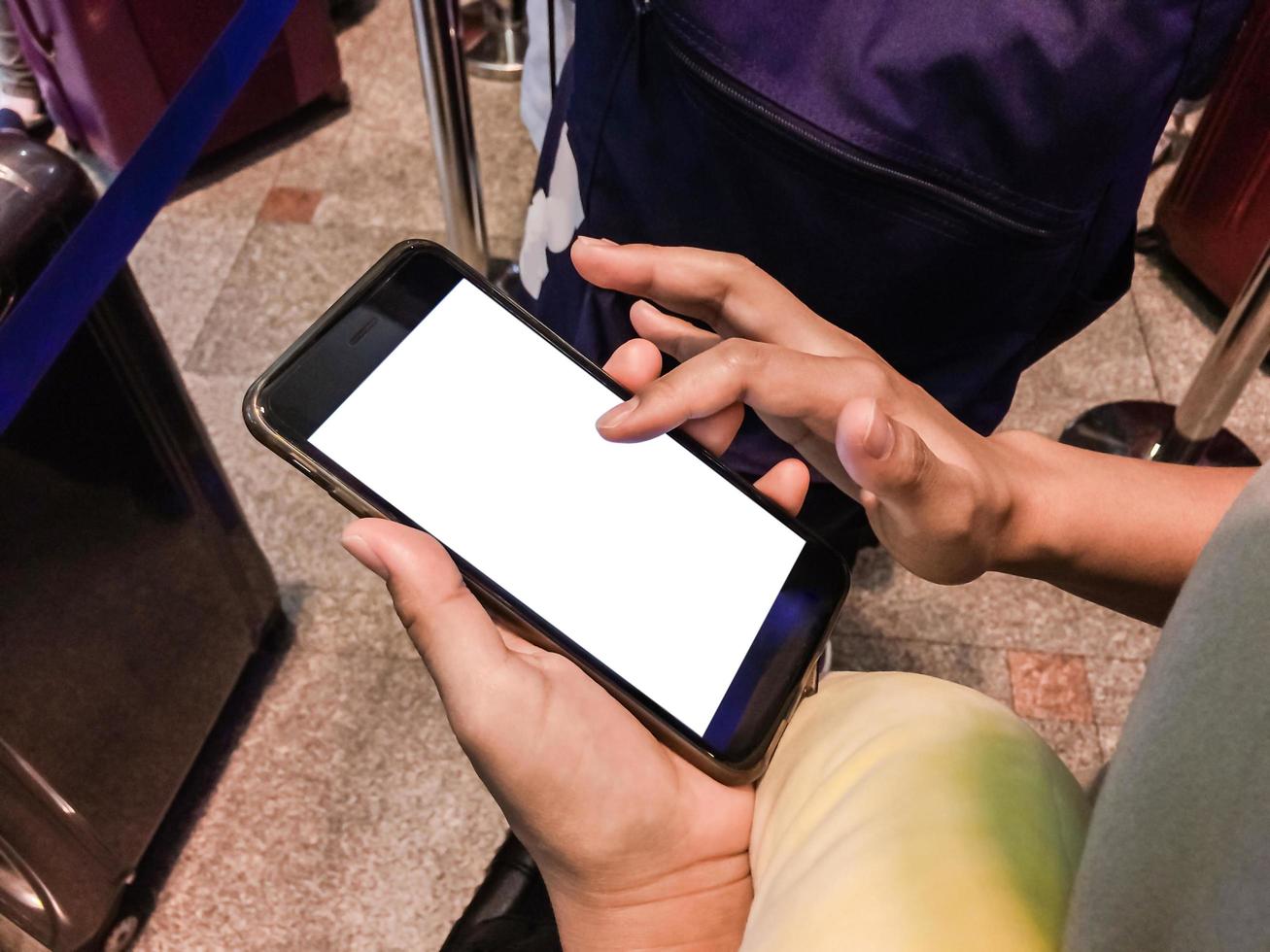 una pasajera usa un smartphone en las terminales del aeropuerto para registrarse en línea y esperar un documento. foto