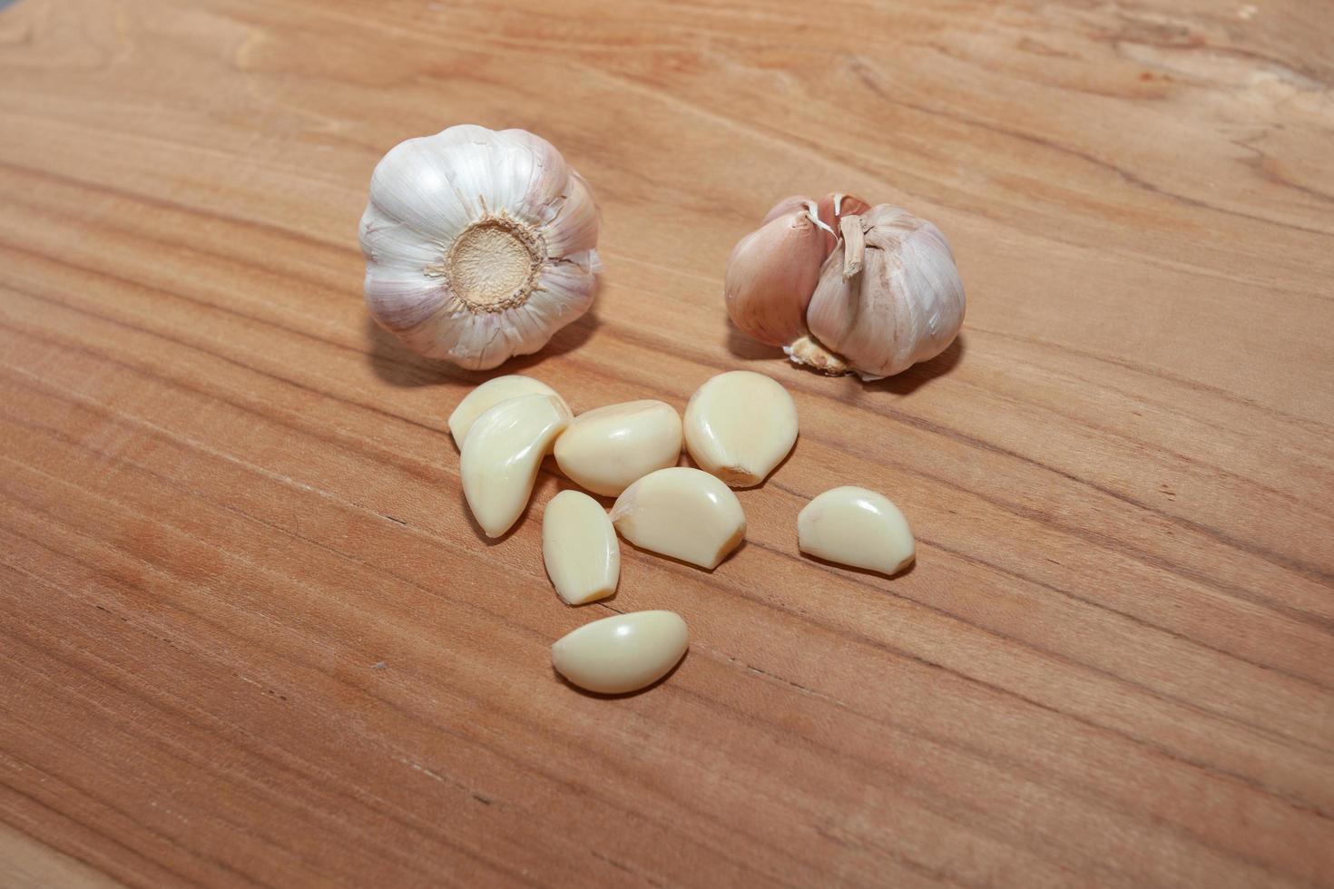 white garlic on wooden floor for cooking photo