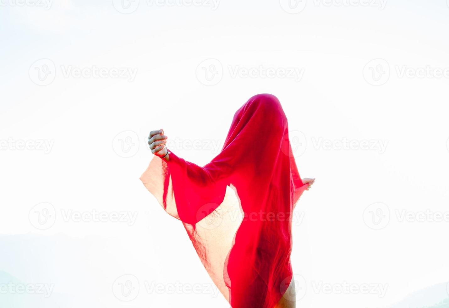 Woman wrapped in a red scarf in the wind photo