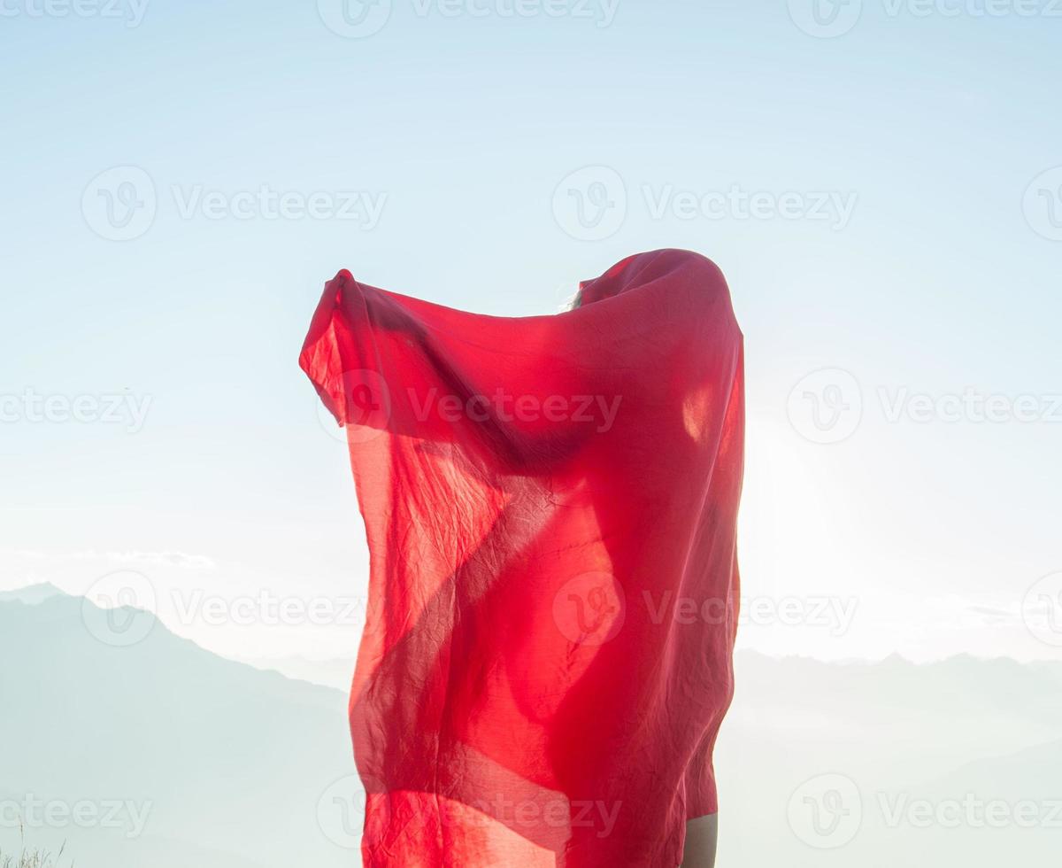 Woman wrapped in a red scarf in the wind photo