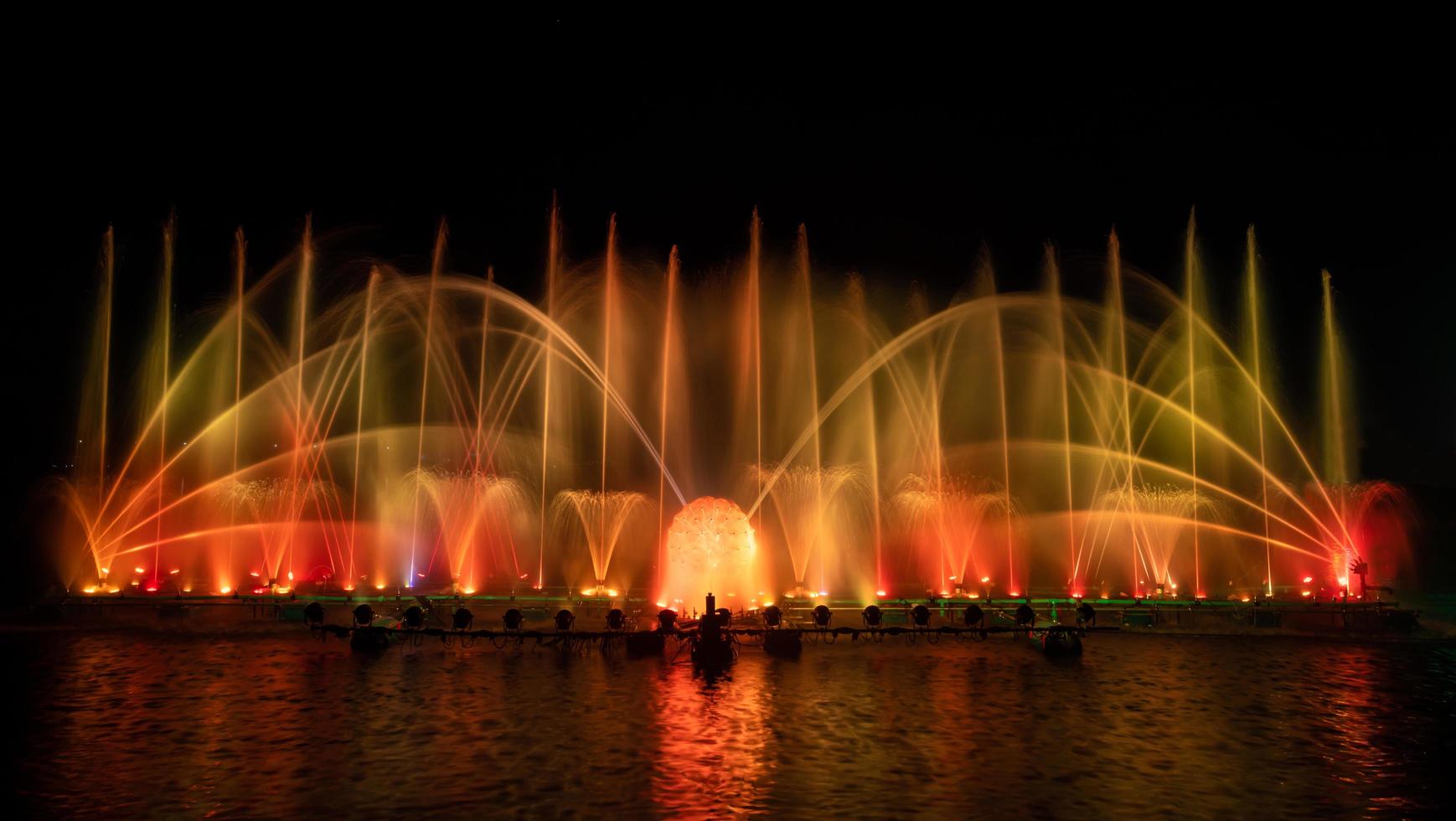 la fuente colorida bailando en celebración del año con fondo de cielo nocturno oscuro. foto