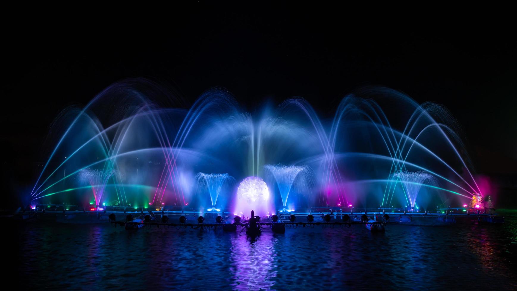 la fuente colorida bailando en celebración del año con fondo de cielo nocturno oscuro. foto