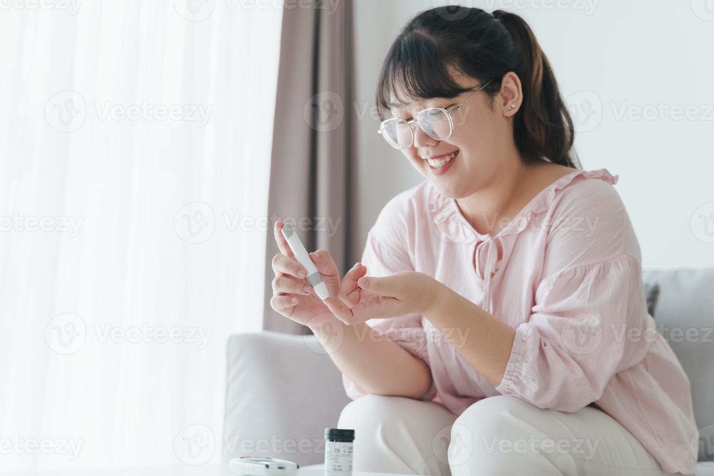 Asian woman using lancet on finger for checking blood sugar level by Glucose meter, Healthcare and Medical, diabetes, glycemia concept photo