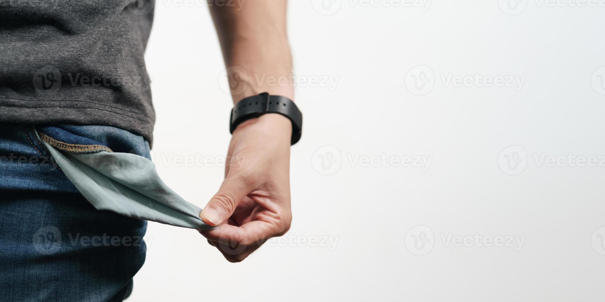 hombre sacando el bolsillo de la mezclilla para mostrar el bolsillo vacío. quiebra, mala economía, sin concepto de dinero. foto