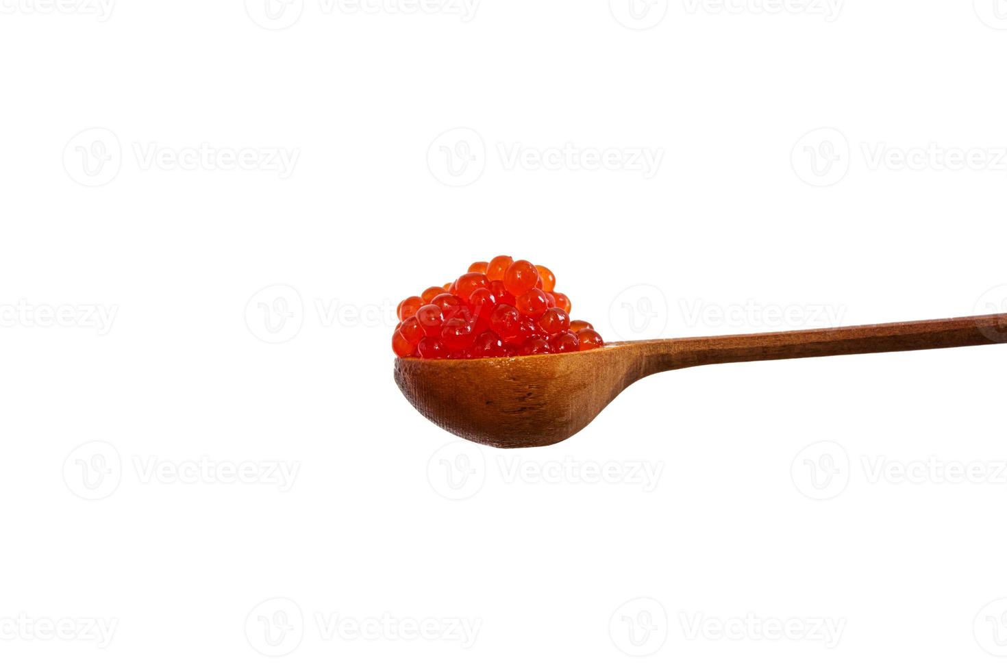 Red caviar in the wooden spoon isolated on white background. photo