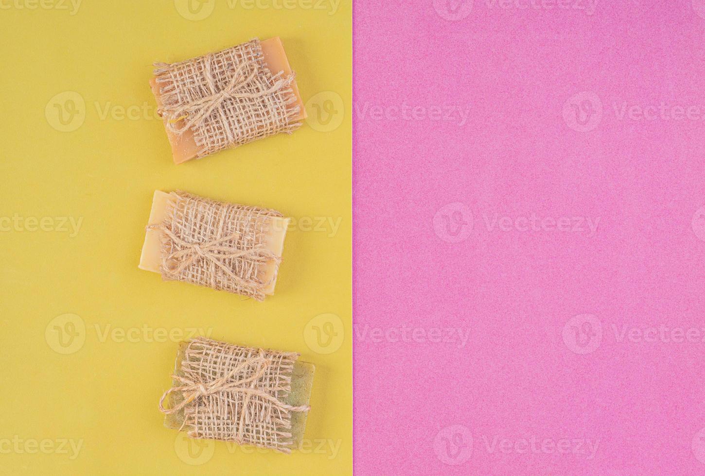 Hand made soap bars on pink-yellow background. Top view. Mockup for design photo