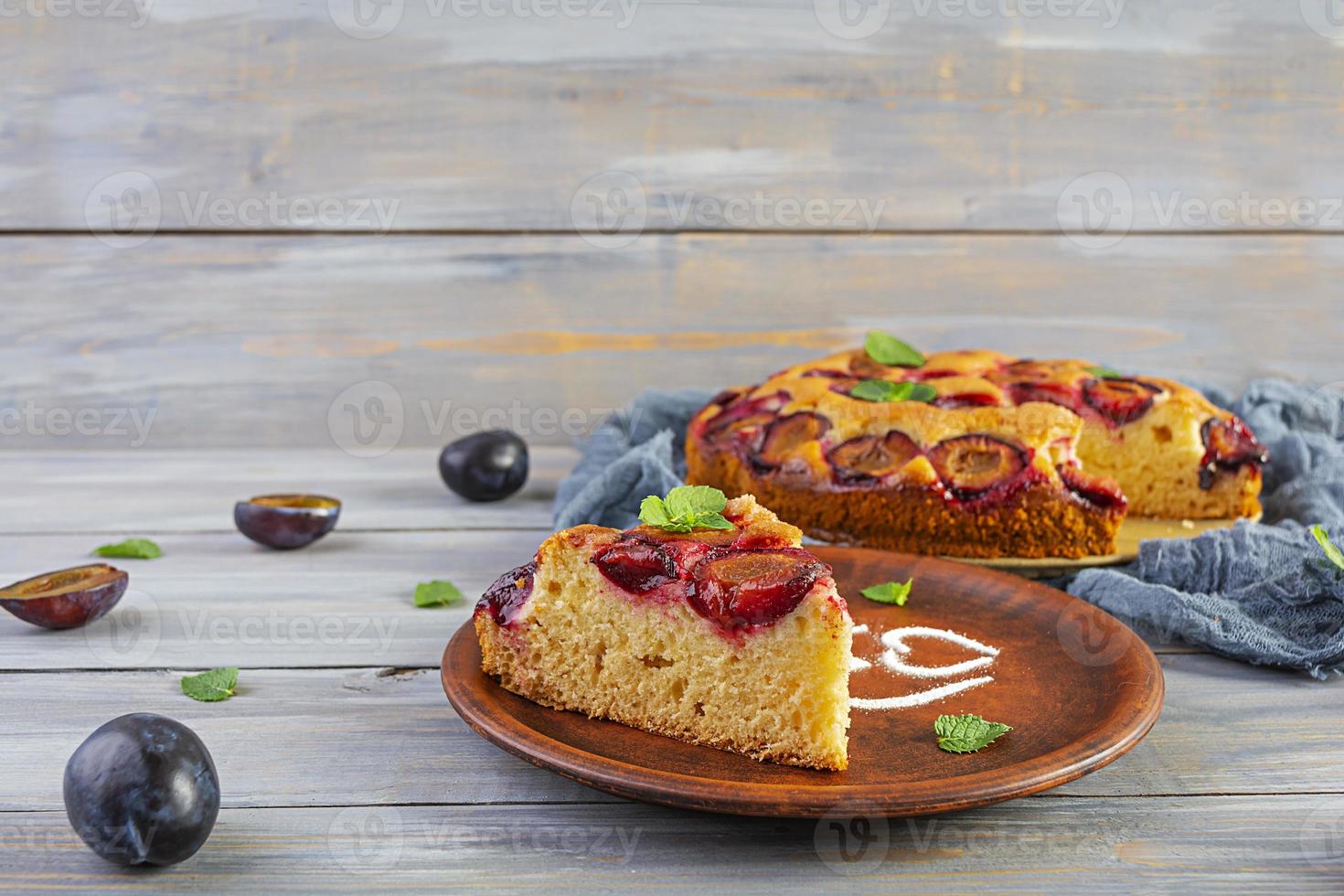Delicious homemade plum pie on wooden background photo