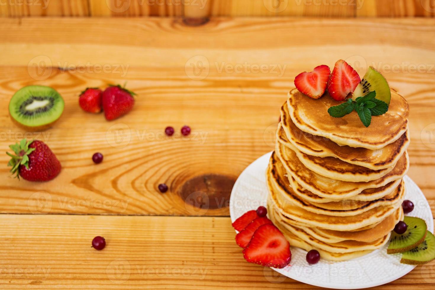 Delicious pancakes on wooden background photo