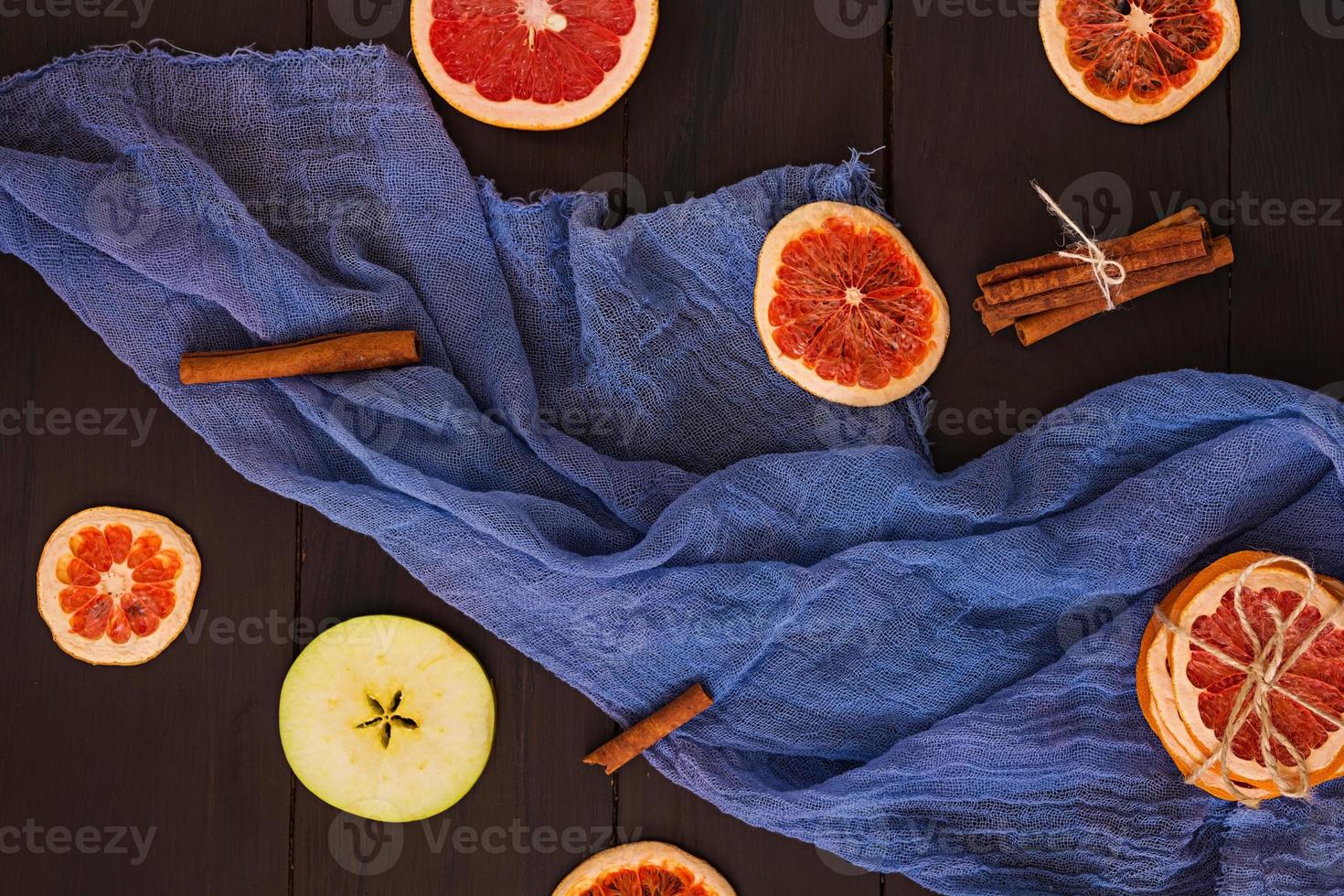 Apple, grapefruit and cinnamon on wooden background. Ingredient for hot mulled wine. Top view photo