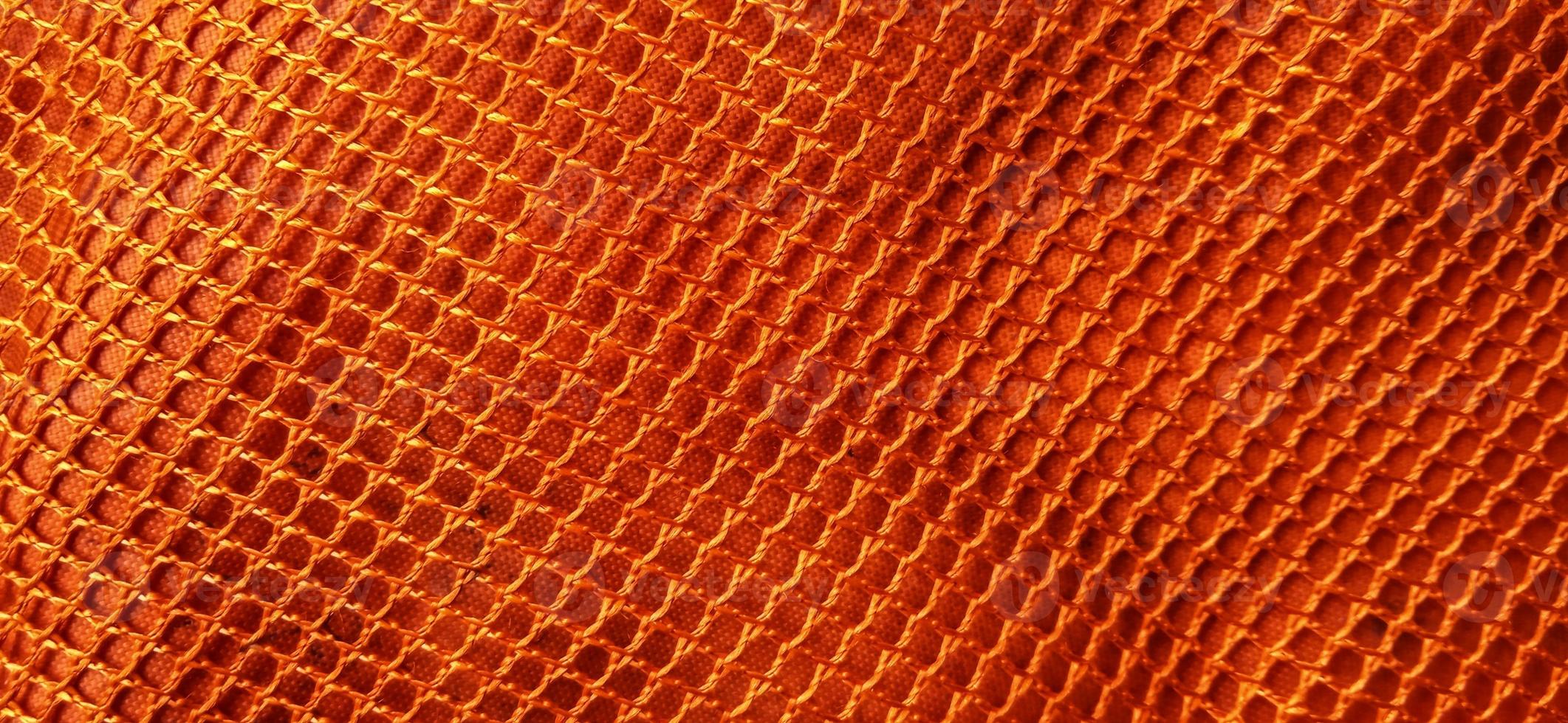 Gold orange honeycomb net patterns backgrpund. Synthetic honeycom net structure fabric background design. Available for text. Suitable for poster, backdrop, presentation, wallpaper, advertising, etc. photo