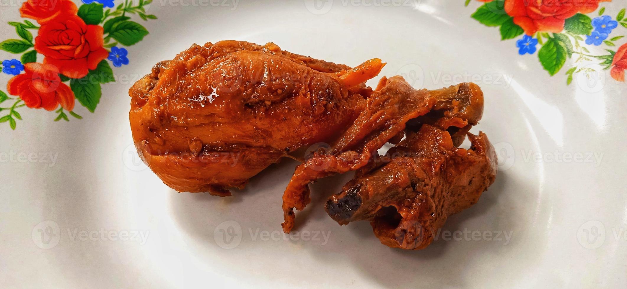 A brown chicken with sweet soy sauces under white gray plate background. Food ingredient background design. Suitable for advertising of food, drink, poster, backdrop, food company and industry. photo