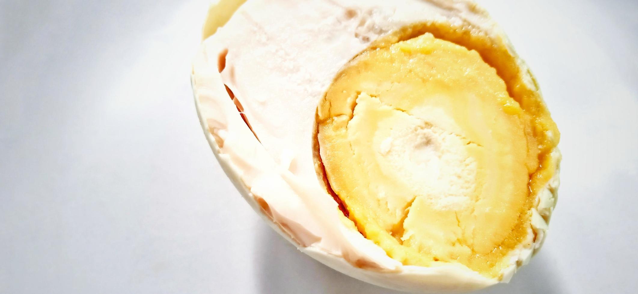 Indonesian food slice of salted egg or telur asin on the white gray plate background. Food ingredient background design. Suitable for advertising of food, drink, poster, backdrop, food company, etc. photo