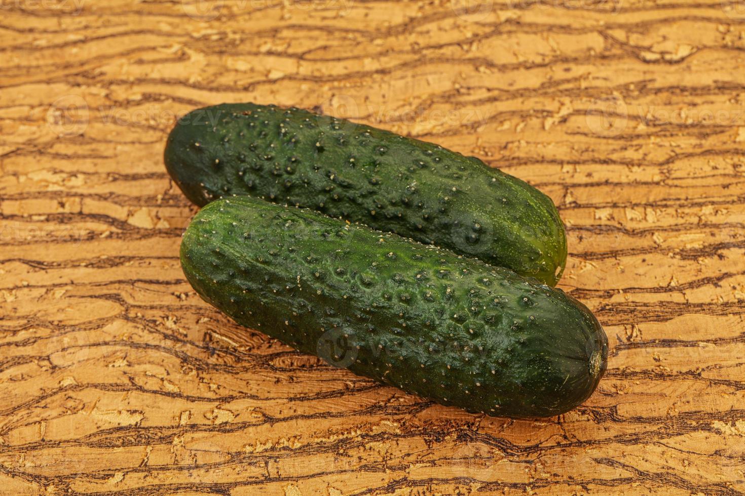 Green fresh cucumbers over background photo