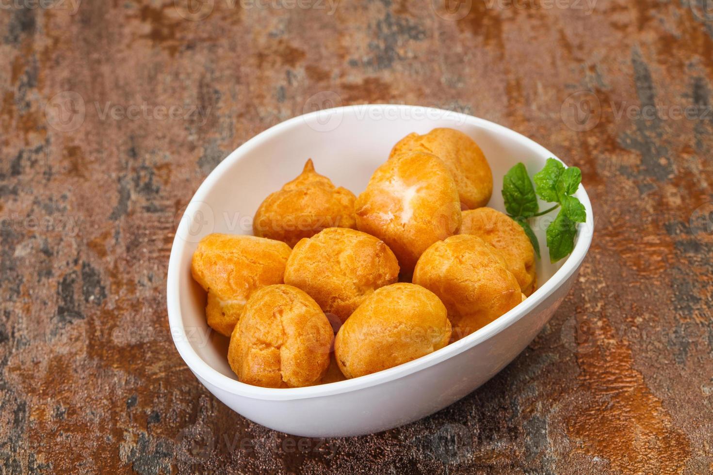 Sweet tasty profiteroles heap in the bowl photo