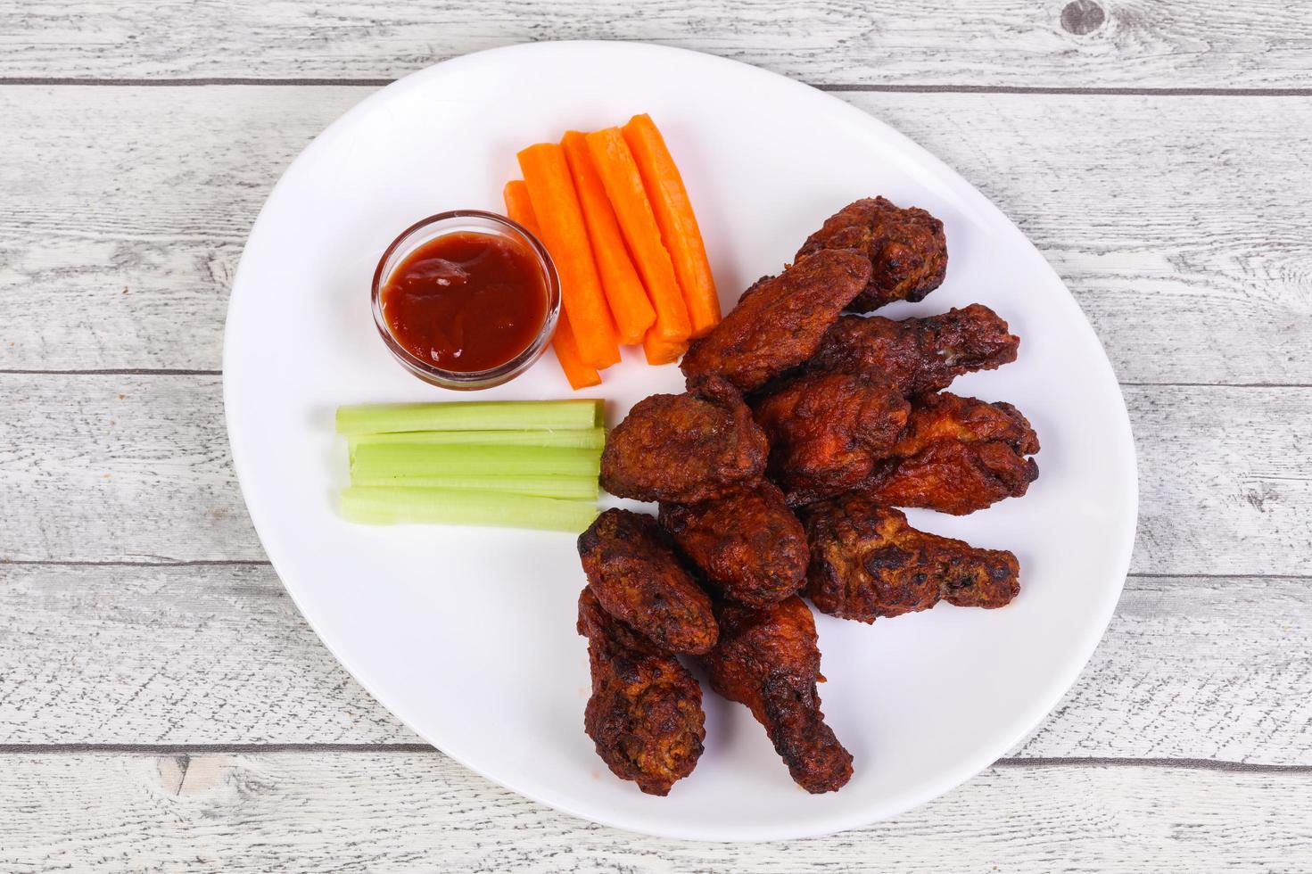 alitas de pollo a la barbacoa con apio y zanahoria foto